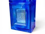 a blue glass block with a silver square in it