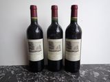three bottles of wine sitting on top of a table next to each other