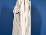 an image of a white coat on a stand against a blue wall