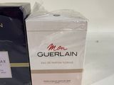 two boxes of perfume sitting next to each other on a table