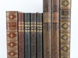 plusieurs vieux livres sont alignés sur une surface blanche