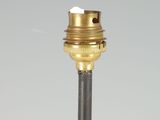 a close up of a brass colored light bulb on a black pole