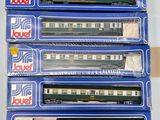 quatre trains miniatures dans leurs boîtes, empilés les uns sur les autres