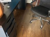 a desk with a chair and a computer on it