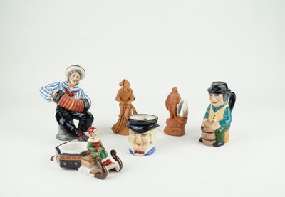 cinq figurines représentant des personnes assises sur une surface blanche
