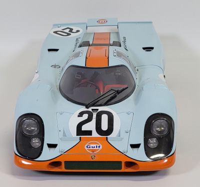 a blue and orange race car on a white surface