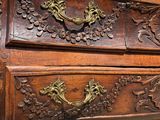 a wooden chest of drawers with ornate carvings on it