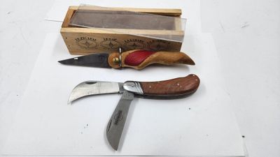 deux couteaux et une boîte posés sur une surface blanche