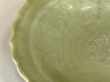 a green bowl sitting on top of a white table