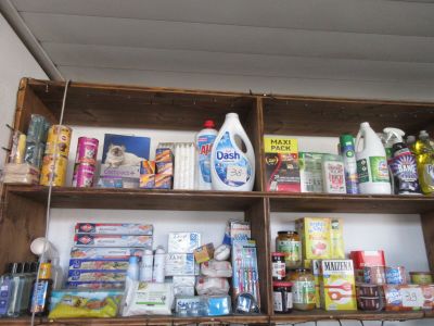 une étagère en bois remplie de nombreux produits alimentaires et d'entretien
