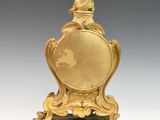 an image of a gold clock with a bird on top of it