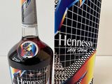 the bottle of henness is next to the box on the table