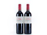 two bottles of red wine sitting next to each other on a white surface