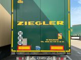 un camion vert garé sur un parking