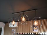 three light bulbs hanging from the ceiling of a restaurant