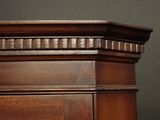 a close up of a wooden cabinet with a clock on it