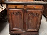 une armoire en bois surmontée d'un plateau en marbre