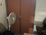 un bureau avec un ventilateur et une chaise dans une pièce