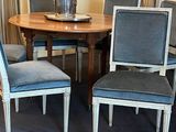 four chairs around a table with a vase of flowers on it