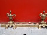 two gold vases sitting on the edge of a red wall