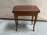 a small wooden table with a small drawer on it