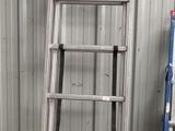a ladder leaning against a wall next to a yellow box