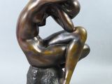 sculpture en bronze représentant un homme assis sur un rocher, la tête entre les mains