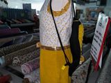 a mannequin with a yellow dress on display in a store