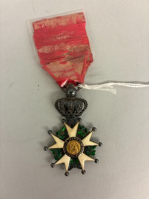 une image représentant une médaille ornée d'un ruban rouge et d'une étoile