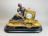 une statue de femme assise au sommet d'une horloge