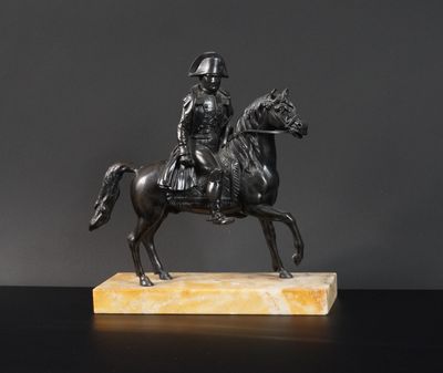 une statue antique en bronze représentant un homme à cheval, posée sur un socle en marbre