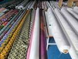 many rolls of fabric on a rack in a room