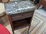 une petite table avec un plateau en marbre dans une pièce