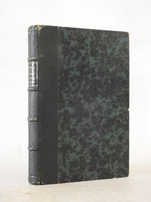 an old book sitting on top of a table next to a white wall