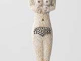statue d'une femme portant des lunettes de soleil sur la tête, posée sur un socle en bois