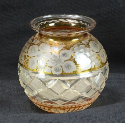 un vase en verre orné d'un motif doré et blanc