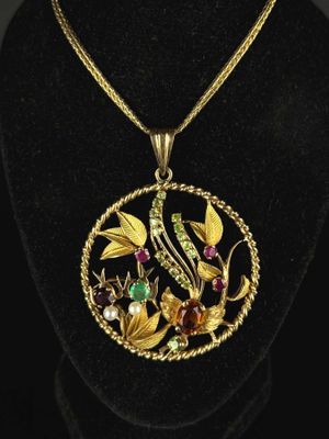 un collier en or orné d'un oiseau et de fleurs