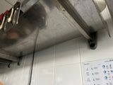 a large stainless steel oven with a bunch of cooking utensils hanging from it ' s hood
