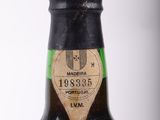 an old bottle of wine sitting on top of a white table