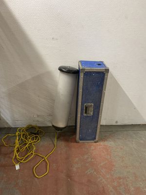 a blue case sitting next to a white wall with a yellow cord