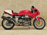 a red motorcycle that is parked in front of a wall