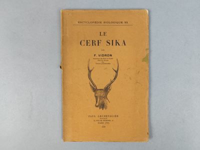 un livre orné d'une tête de cerf, posé sur une table