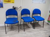 three blue chairs in the corner of a room