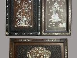 trois œuvres d'art sont exposées sur une surface grise
