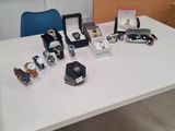 une table blanche sur laquelle sont posés plusieurs montres et d'autres objets