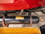 a close up of a red motorcycle with a black cylinder