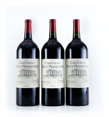 trois bouteilles de vin rouge posées l'une à côté de l'autre sur une surface blanche