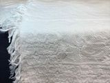 a white blanket on a bed with a blue comforter