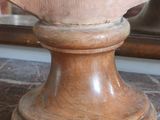 a wooden vase on a marble table with a mirror in the background