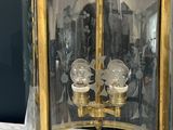 a glass and brass clock on a marble table